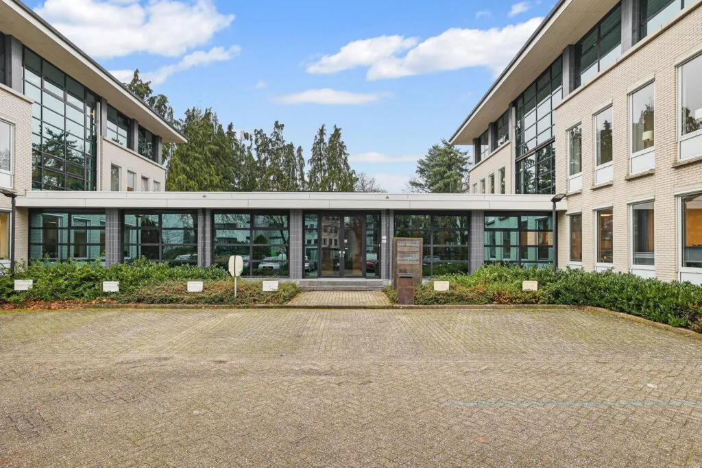 Vooraanzicht van een modern kantoorpand aan de Oude Utrechtseweg met parkeerplaats en groenvoorziening.